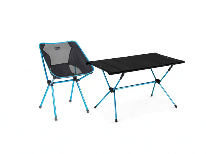 A single camping chair next to camping table.